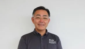 眼鏡をかけダークグレーのポロシャツを着た中年の日本人男性