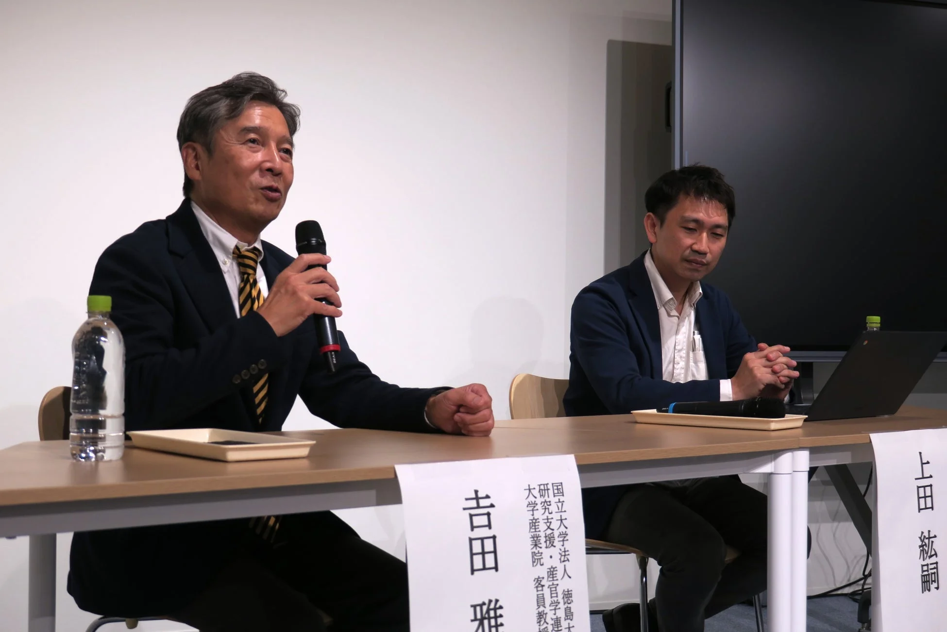 講演中の吉田雅信氏と上田紘嗣氏