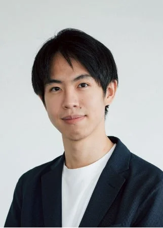 白いTシャツの上に紺色のジャケットを着用した若いアジア人男性のポートレート