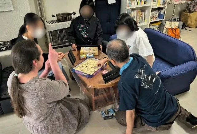 リビングでボードゲームを楽しむ人々