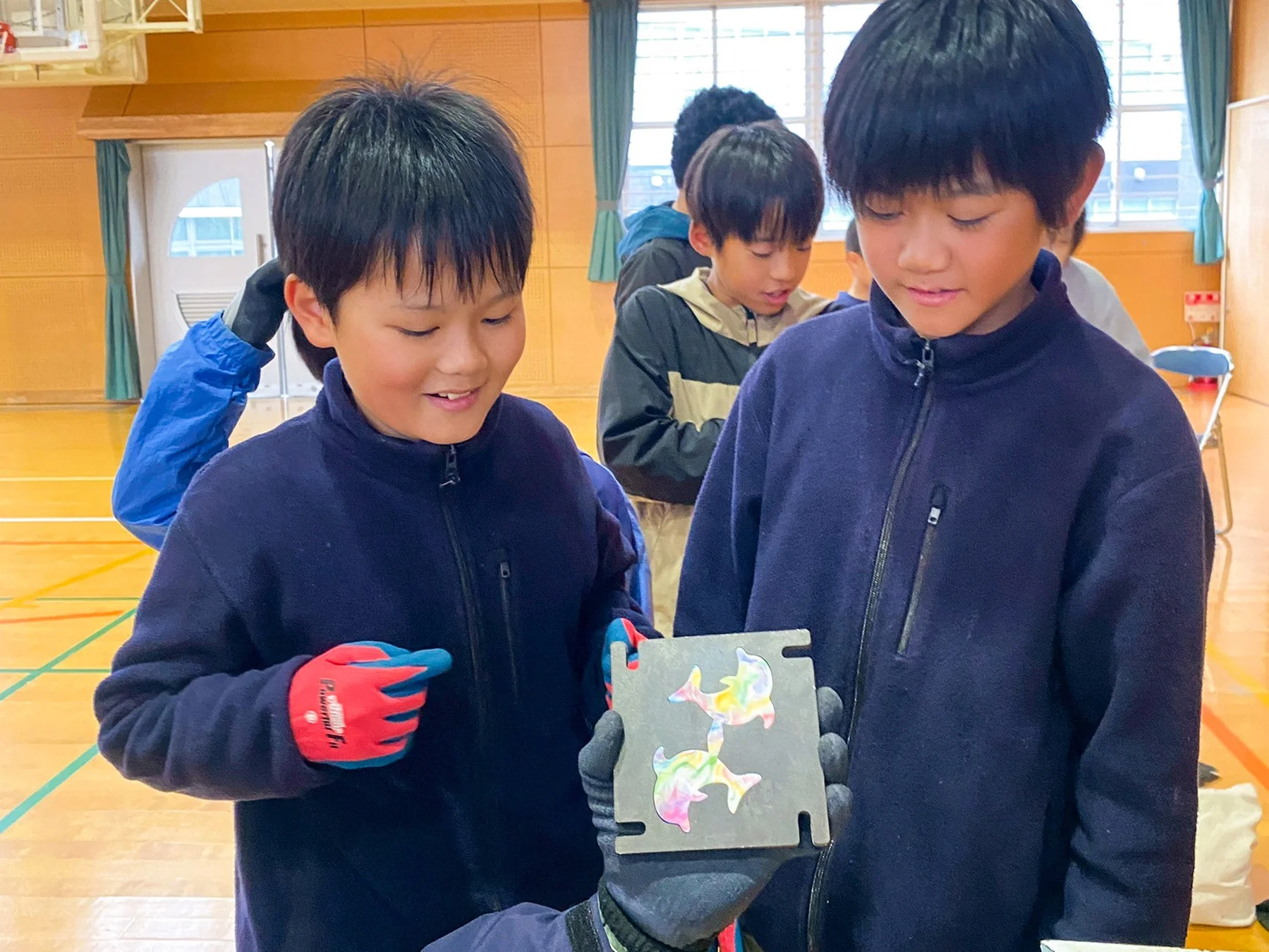 イルカのキーホルダーを見る児童