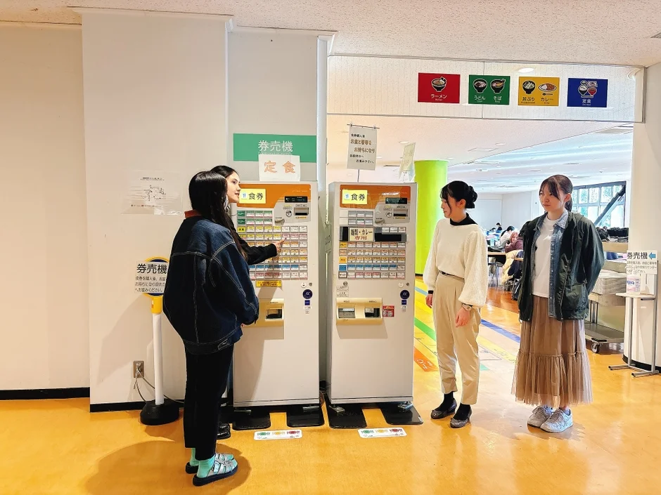 学食の食券販売機と学生たち