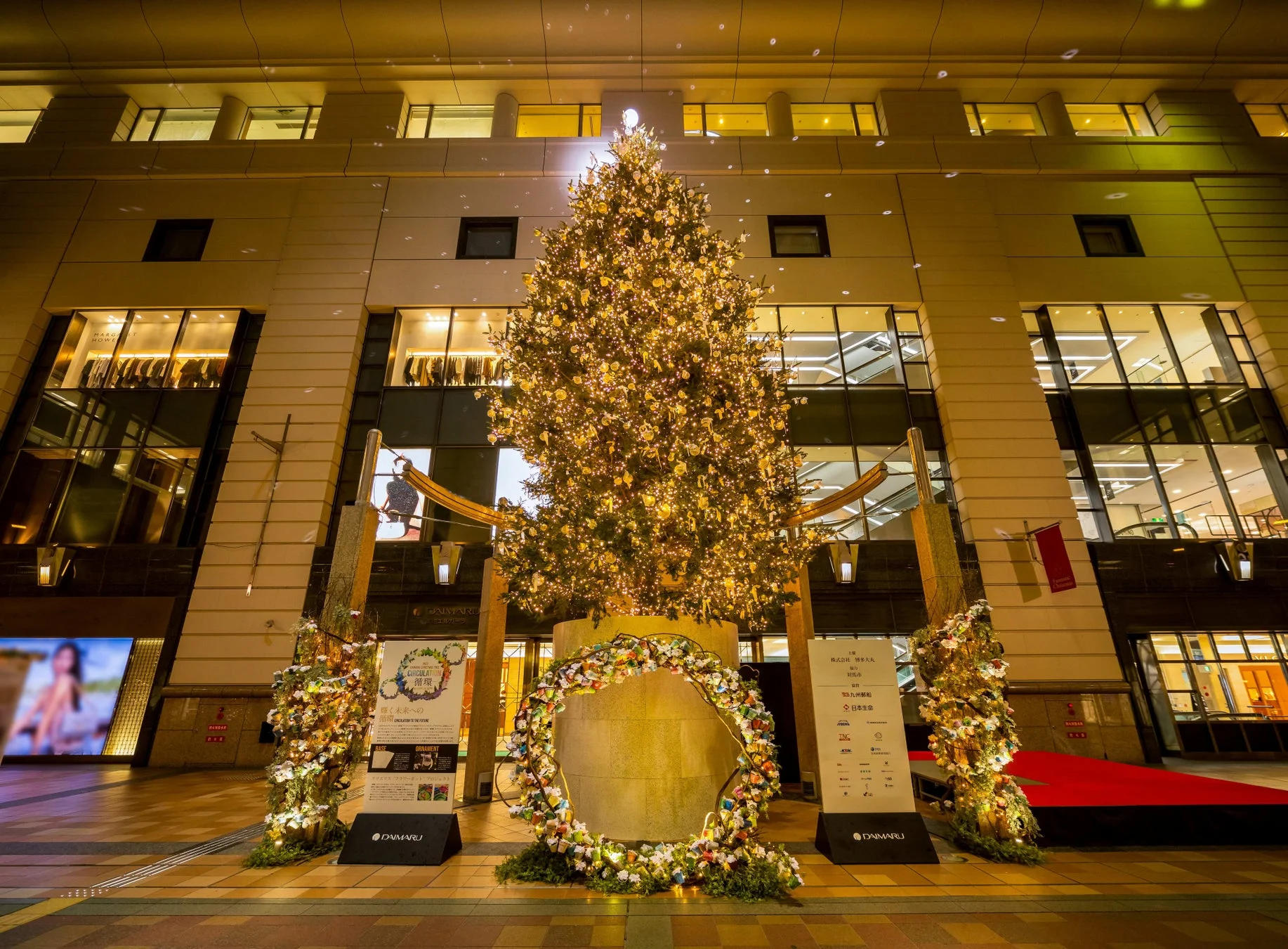 博多大丸前広場に設置された、無数の電飾で輝く巨大なクリスマスツリーと美しい装飾の夜景。