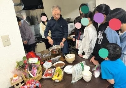 料理教室で大人と子供が調理する様子