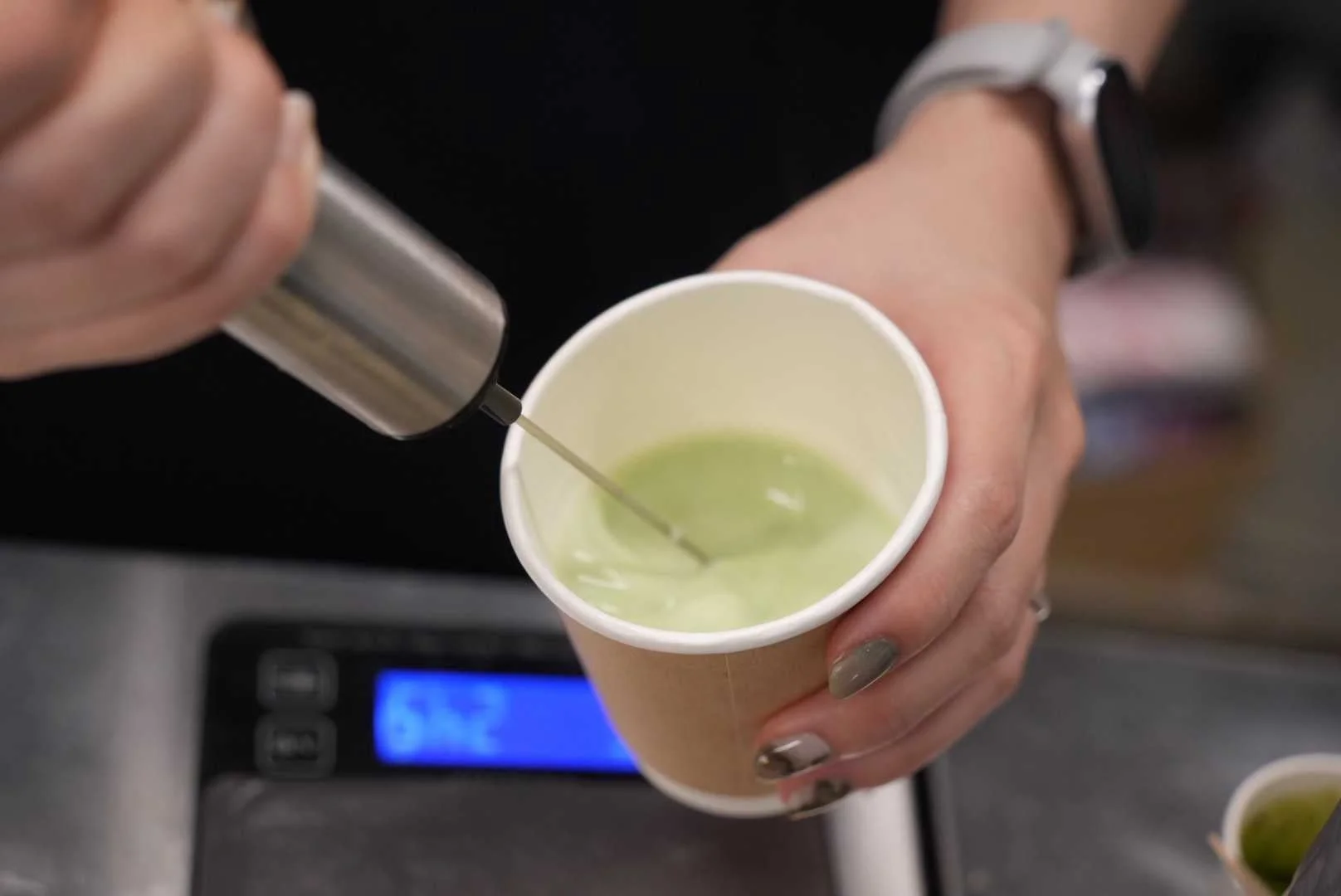 抹茶のような飲み物を混ぜる様子