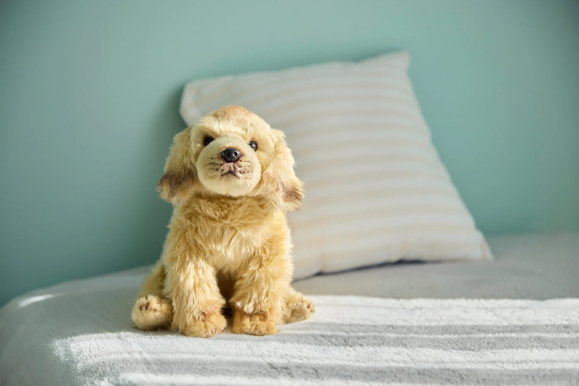 ベッドに座るAIDogのぬいぐるみ