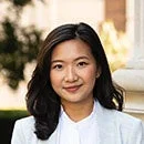 白いジャケットを着用し、やや微笑んでいるアジア人女性のポートレート