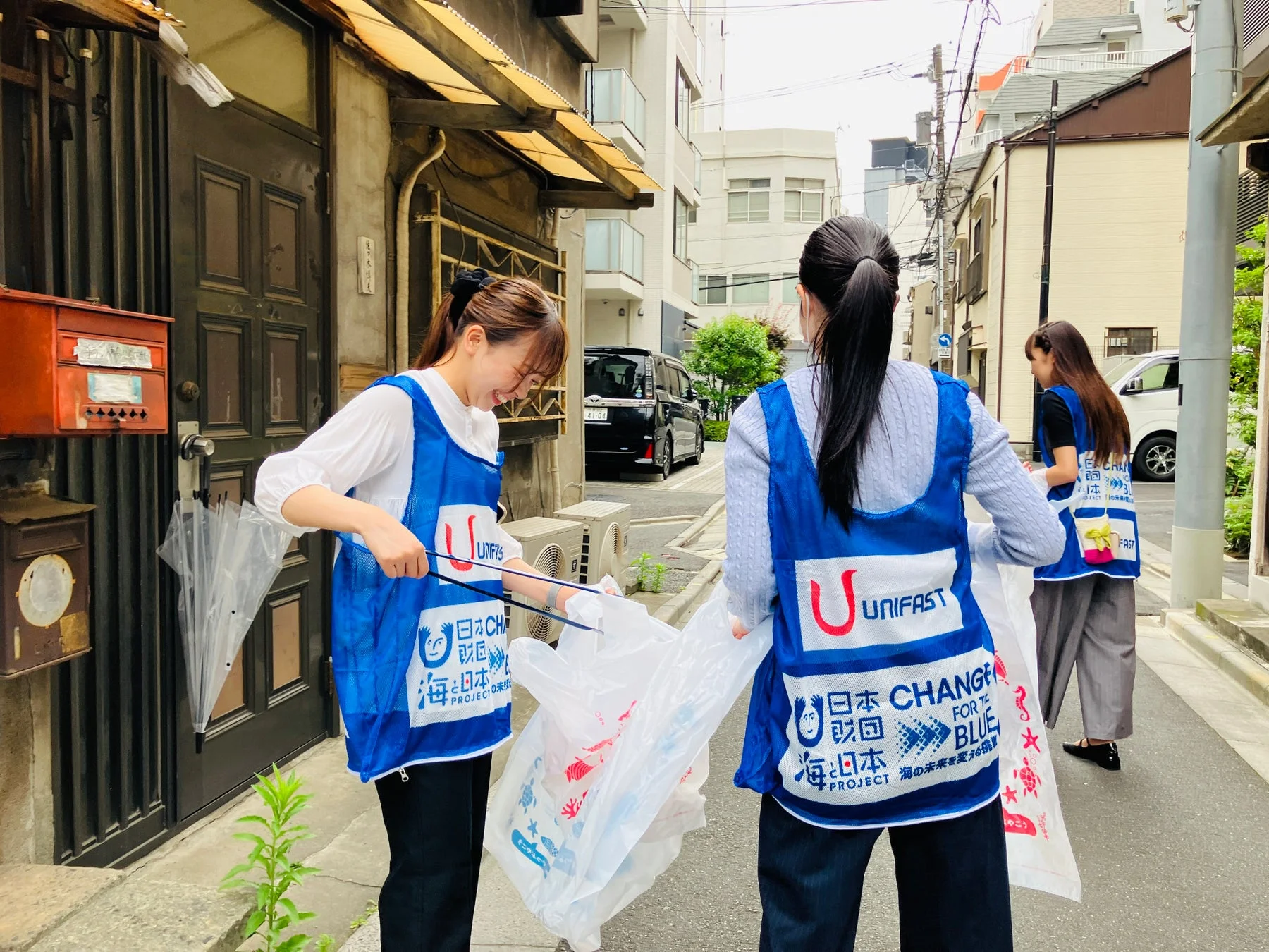 青いベストを着て清掃活動を行う人々の様子