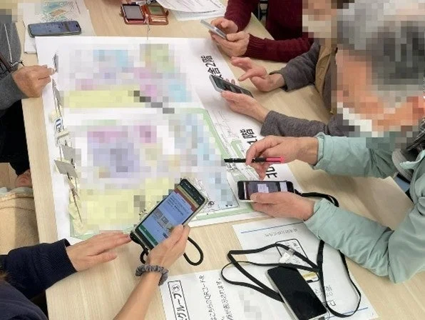 スマートフォンを手に学習会に参加する人々