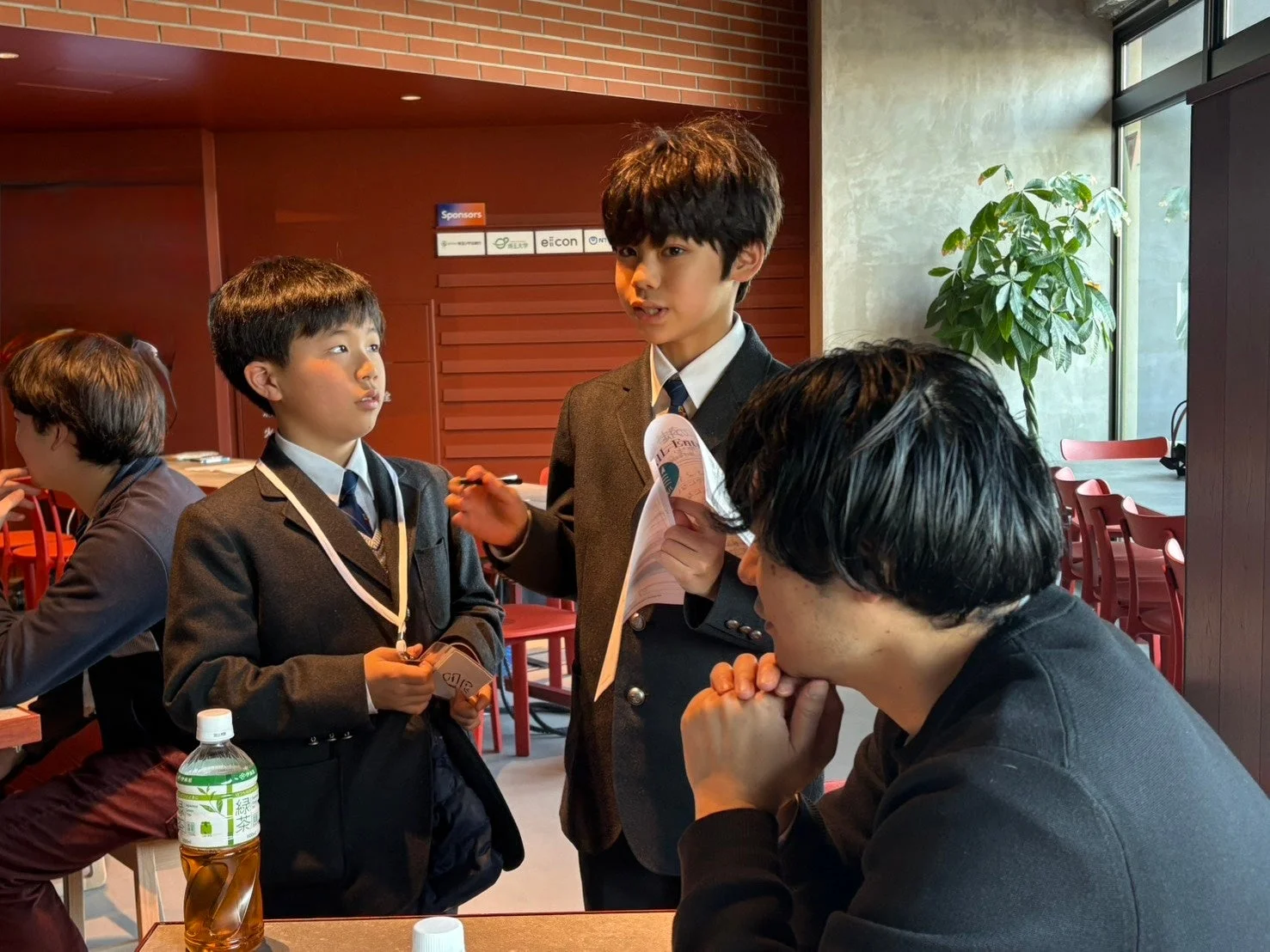 制服の少年2人と大人1人が話している