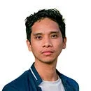 紺色のジャケットを羽織り、カメラをまっすぐ見ている短く黒い髪のアジア系男性のポートレート