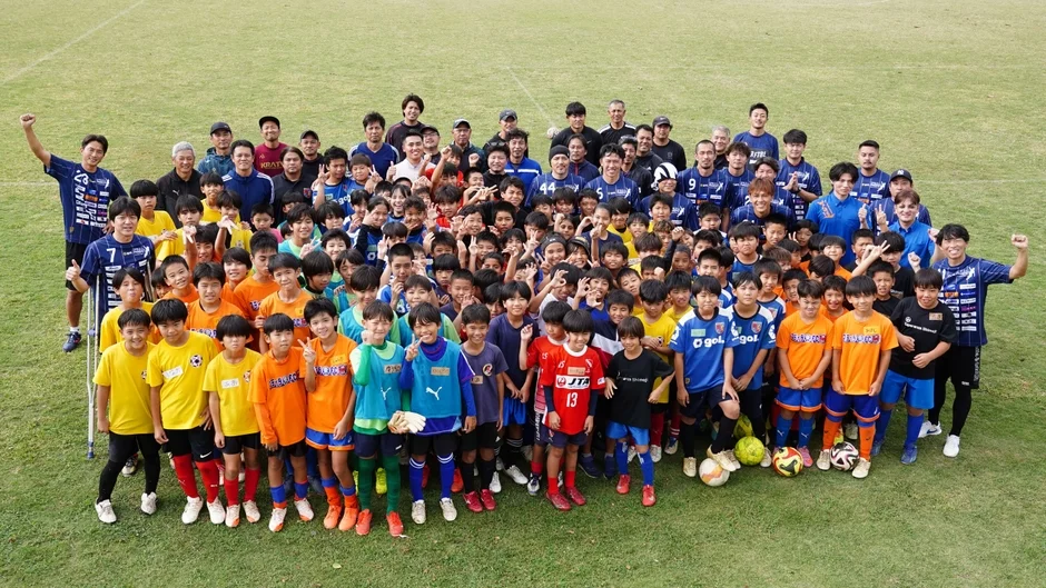 子供たちと元プロサッカー選手たちの集合写真