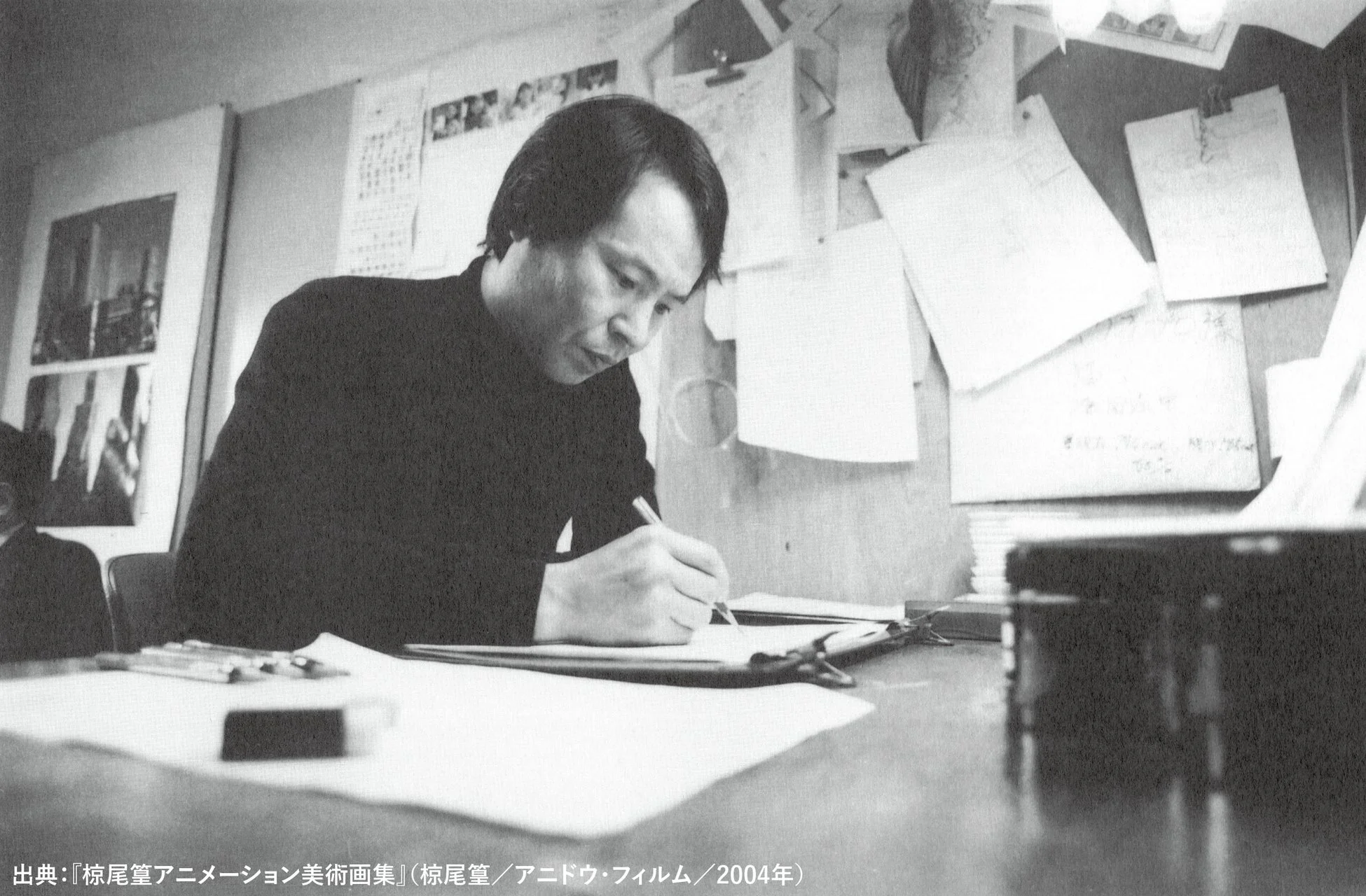 デスクで執筆する椋尾篁氏