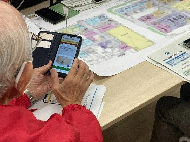スマートフォンで避難所情報を確認する高齢者