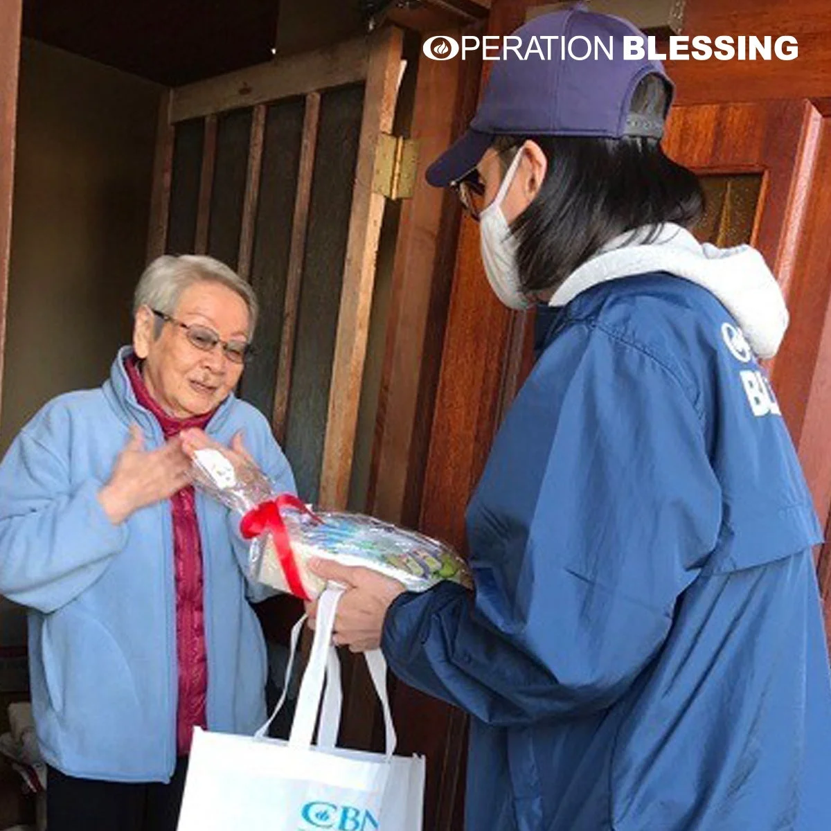 高齢女性に支援物資を渡す様子