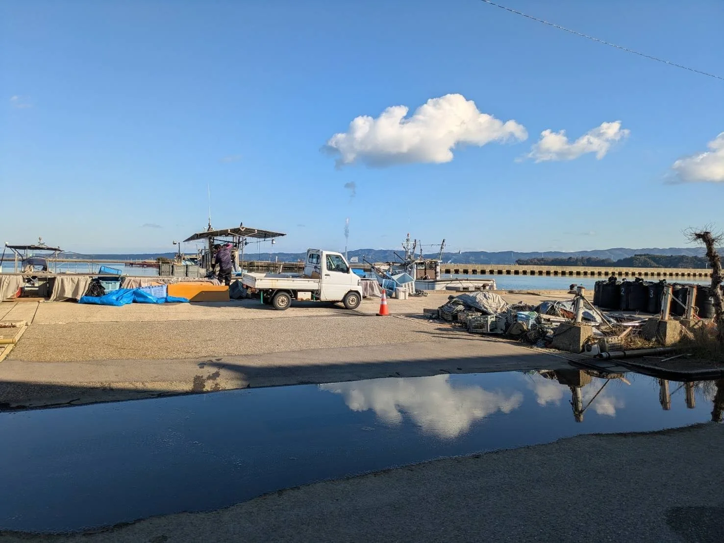 漁港に停泊する漁船と軽トラックの風景
