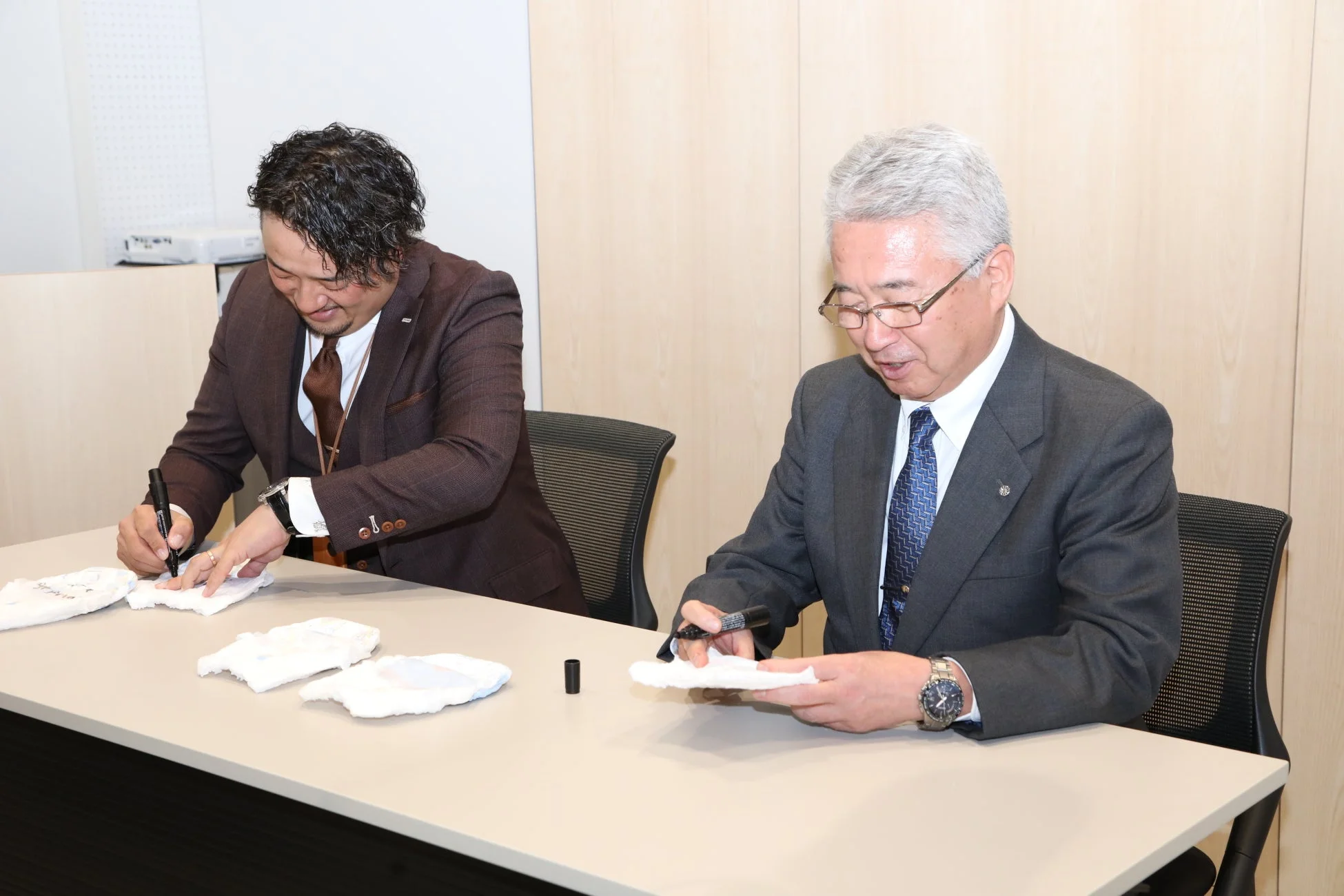 真剣ながらも和やかな雰囲気で、ビジネスシーンにおける共同作業や契約締結のような場面を示唆しています。