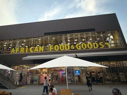 「AFRICAN FOOD & GOODS」の看板がある商業施設の外観