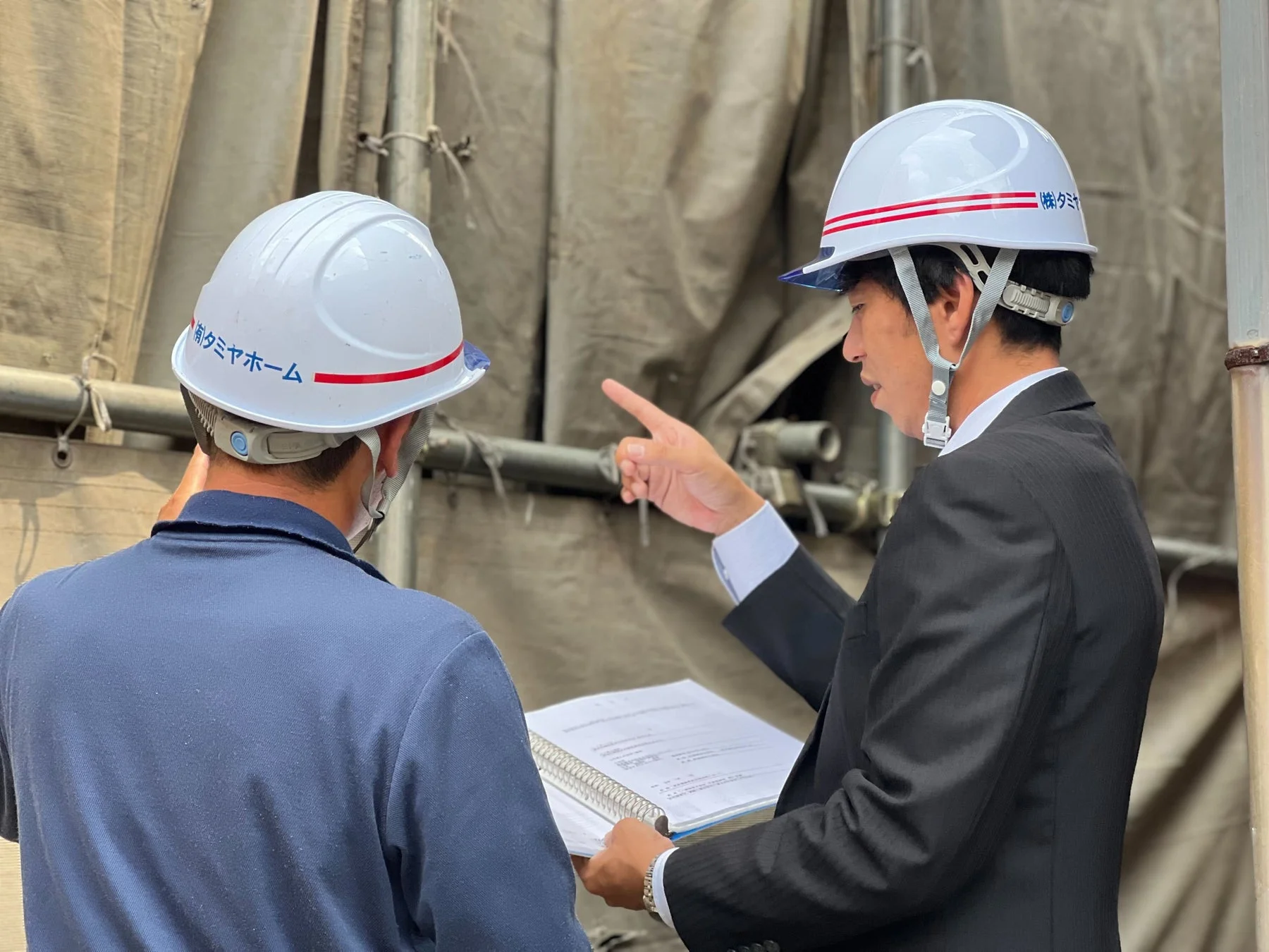 建設現場で打ち合わせをする男性たち