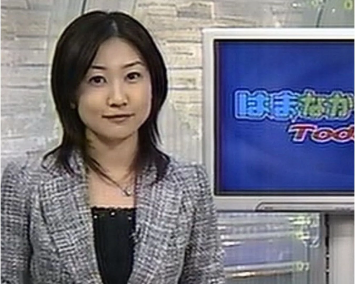 テレビ番組のスタジオに立つ女性アナウンサー