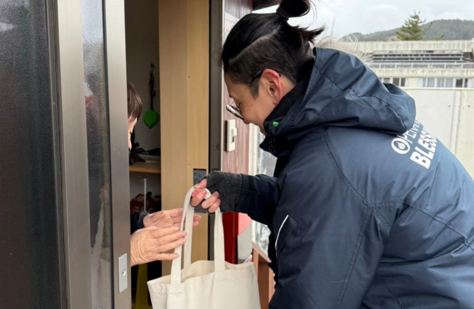 玄関先で物資を手渡す様子