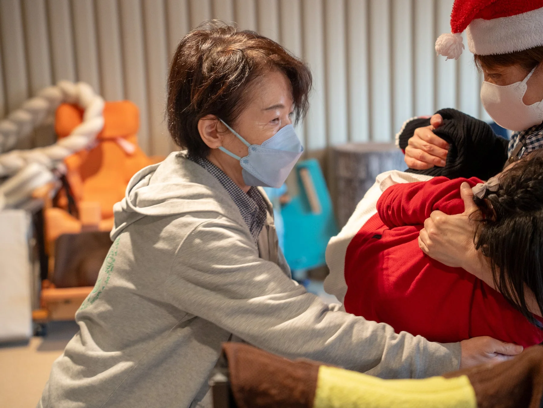 マスクをした女性が子供を抱きかかえる様子