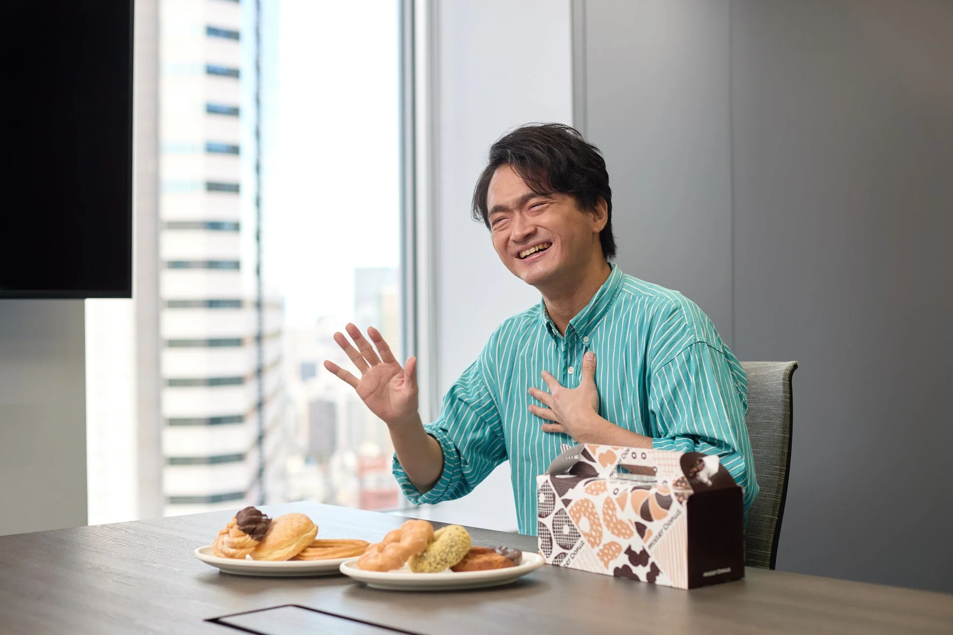 ドーナツを囲んで笑顔の男性たち