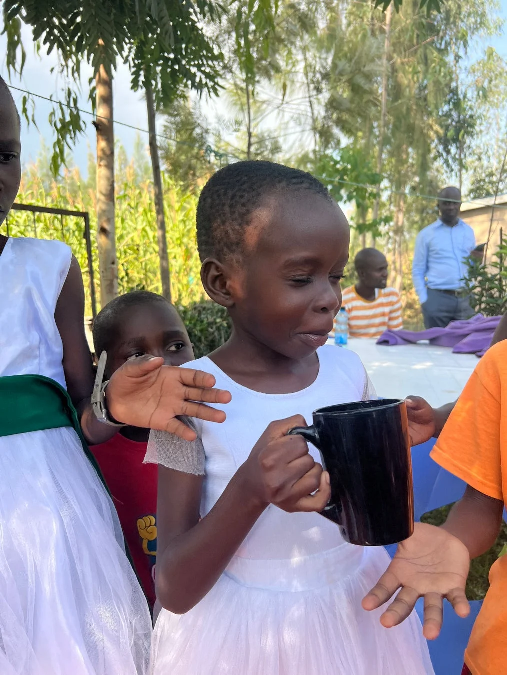 白いドレスの少女とマグカップ