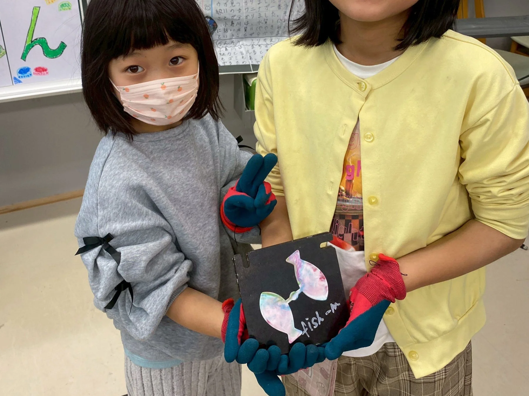 魚の工作を持つ子どもたち