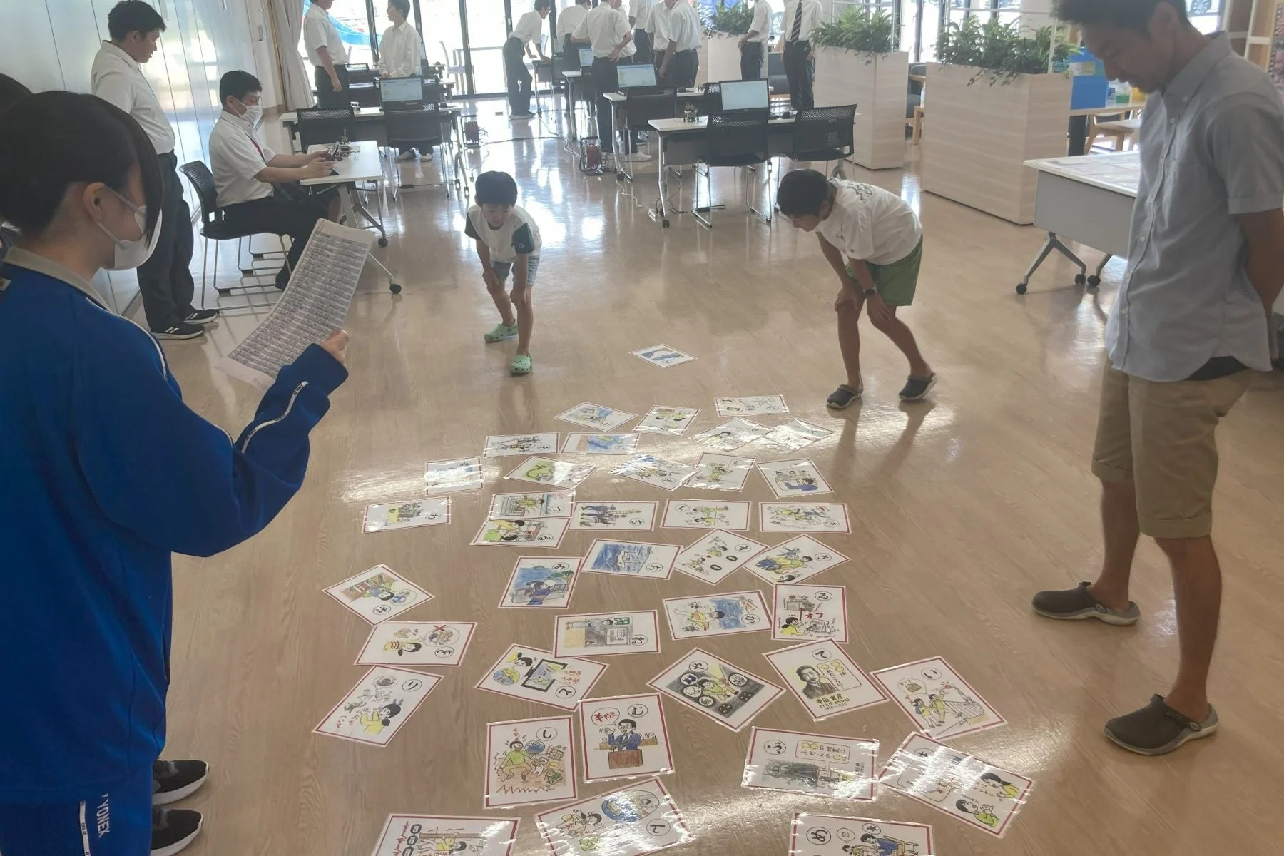 かるたで遊ぶ子どもたちと大人