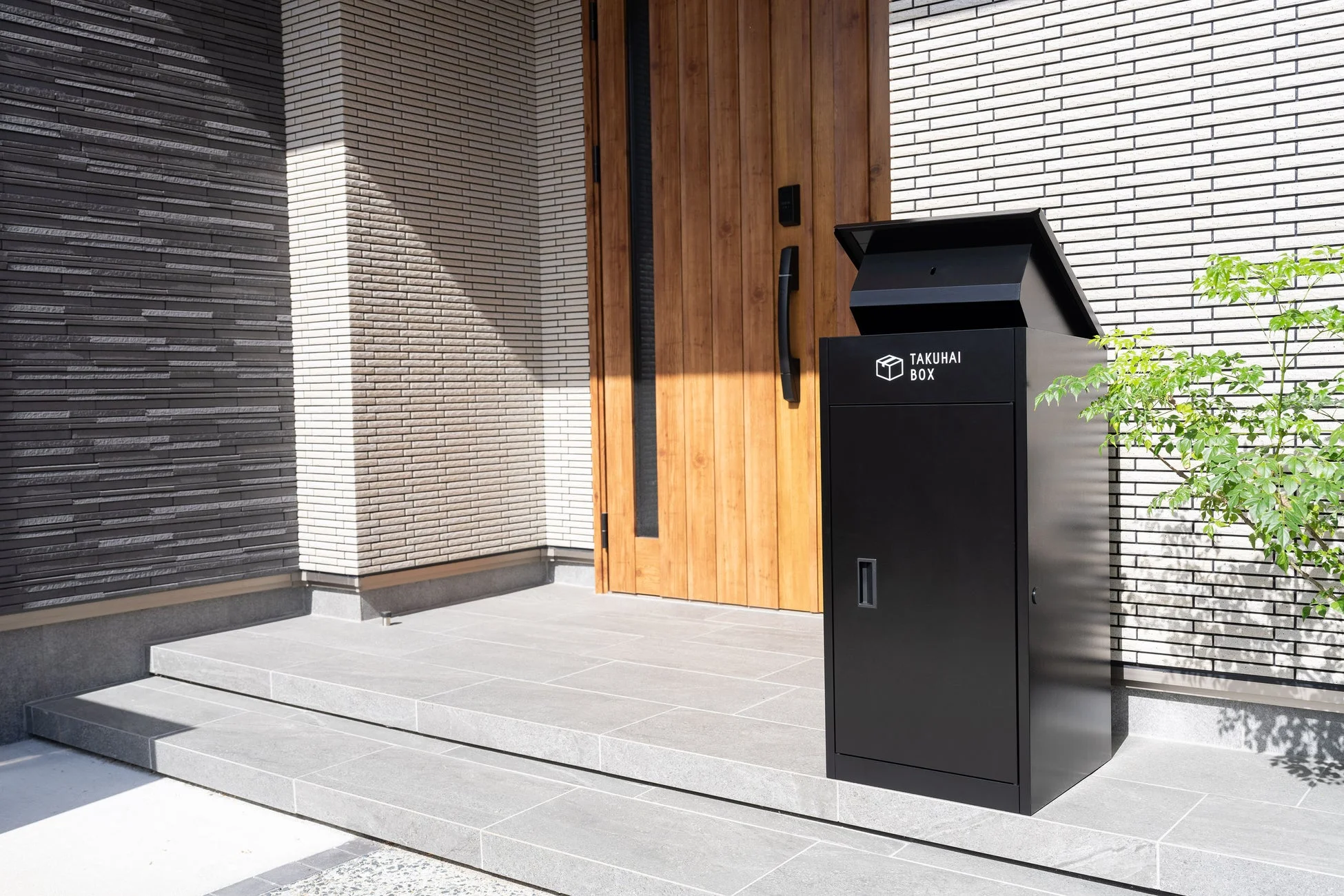 モダンな住宅の玄関に設置された宅配ボックスの画像