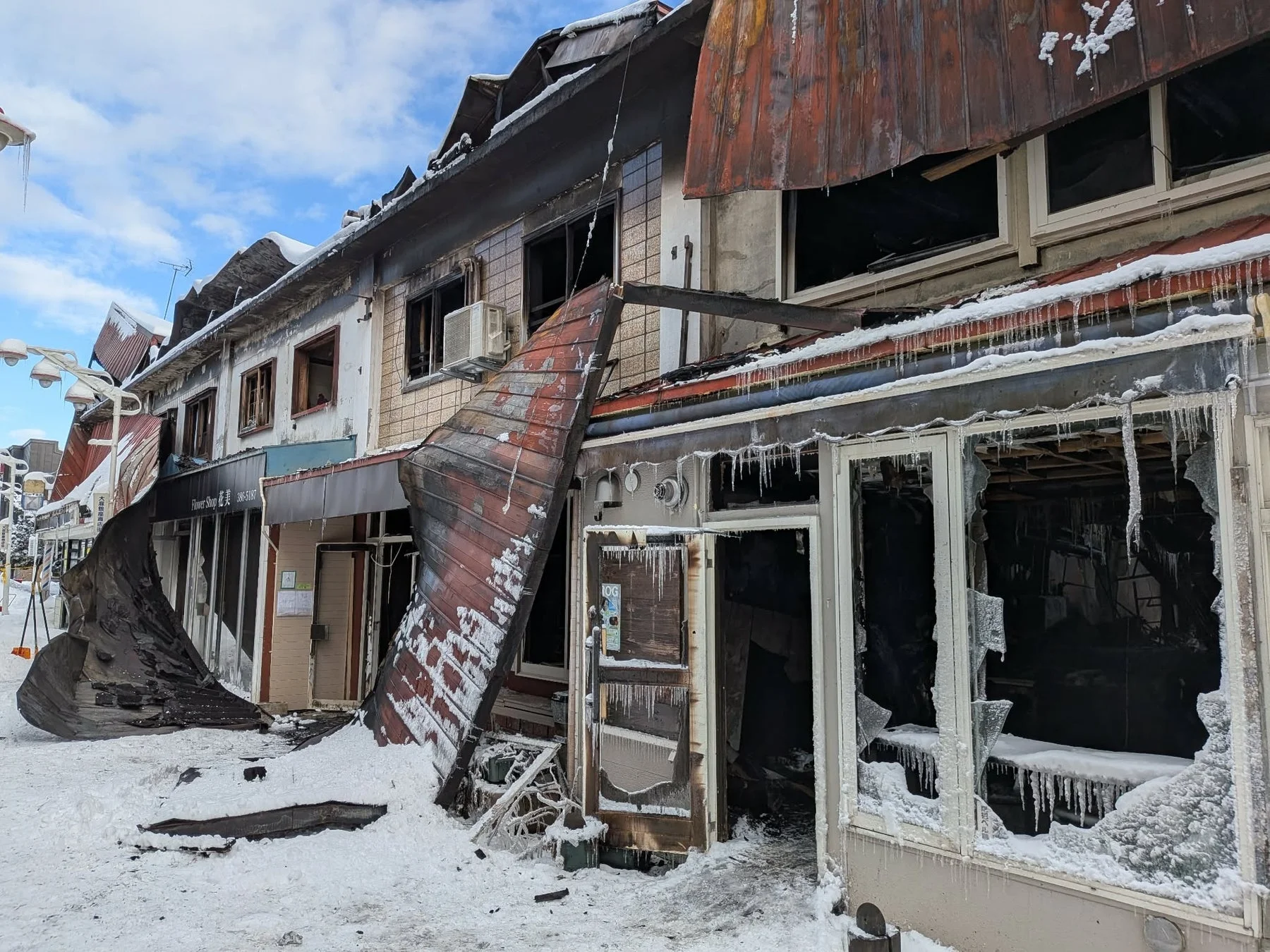 雪が積もった冬の風景の中に、火災で甚大な被害を受けた建物
