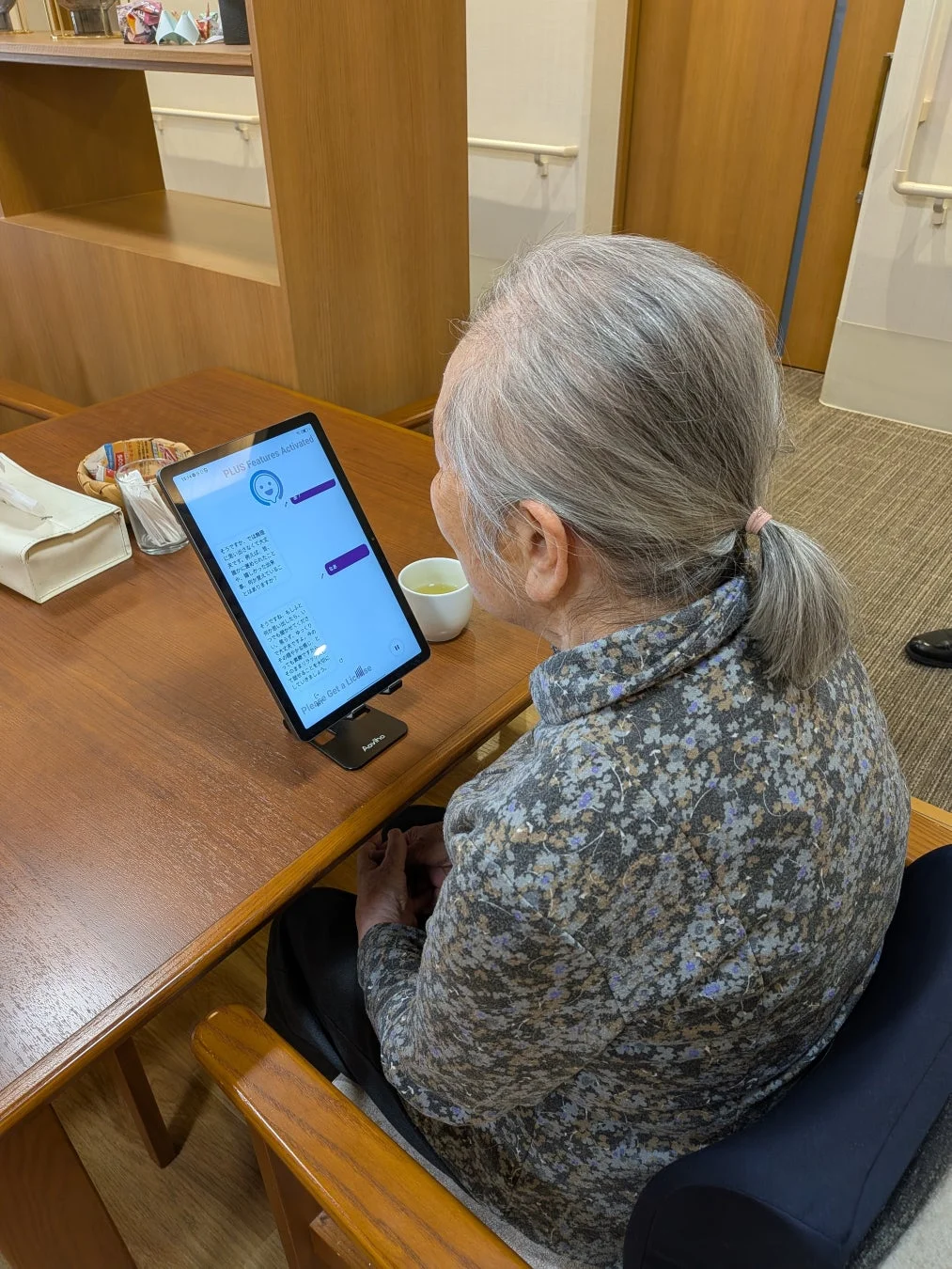 高齢の女性がタブレットを使用している様子