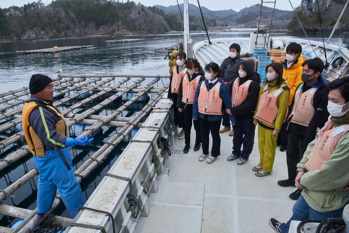 養殖場で説明を受ける学生たち
