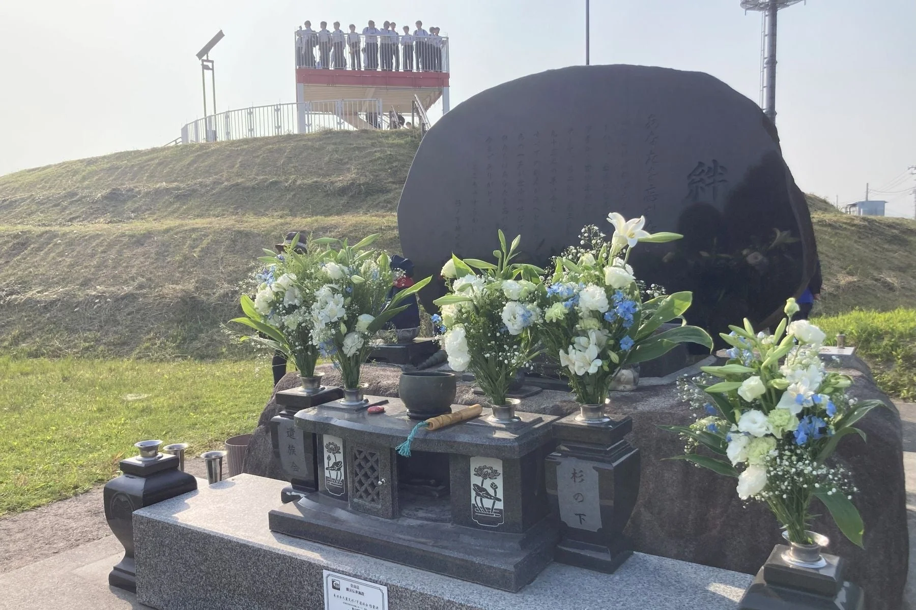 杉の下地区の慰霊碑と人々