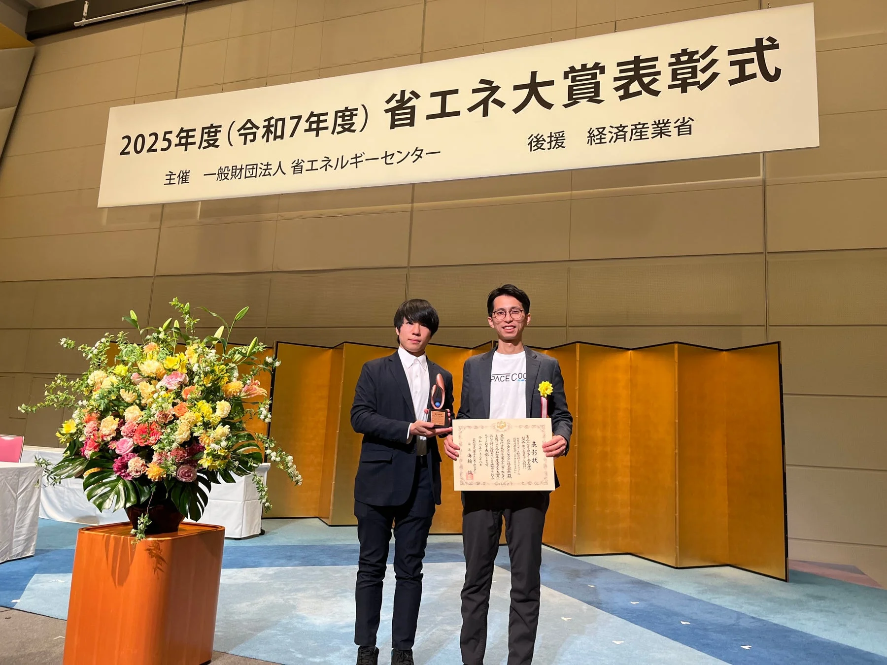 2025年度 省エネ大賞表彰式で受賞者が賞状とトロフィーを持つ様子