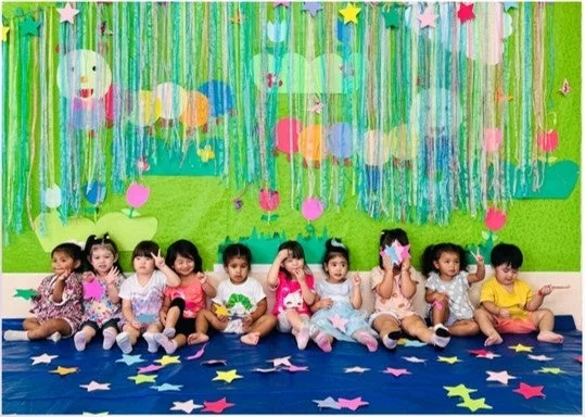 カラフルな装飾の前で座る子供たち