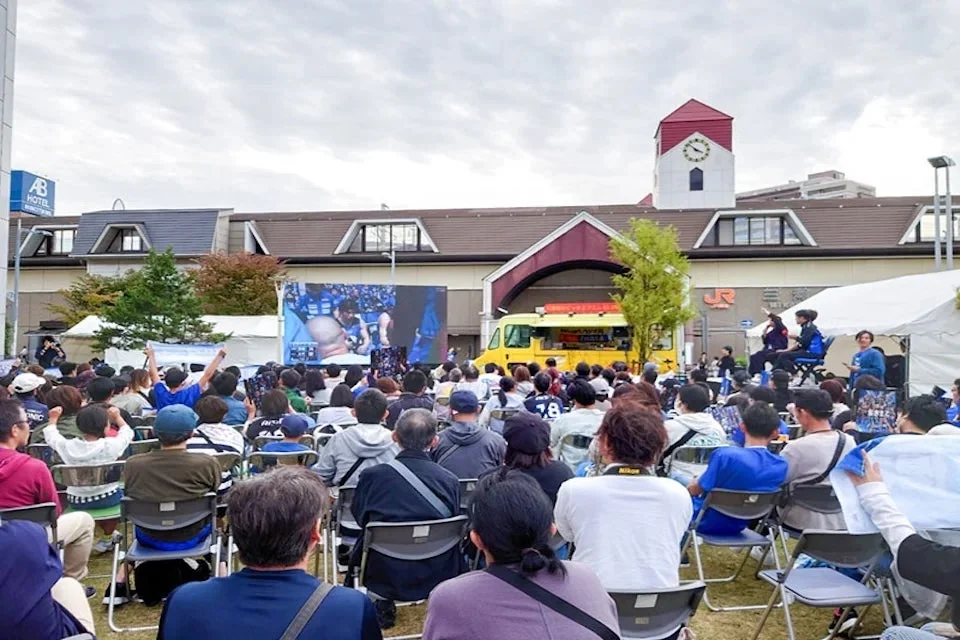 大型スクリーンでスポーツ観戦する群衆