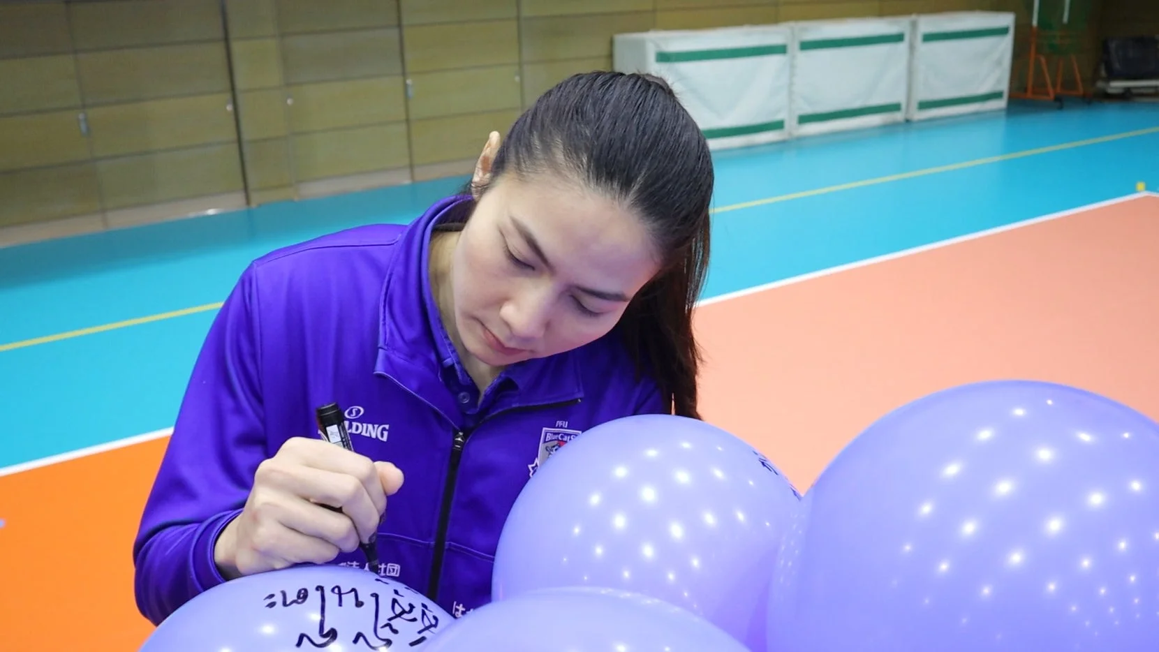 アスリートが風船にサインする様子