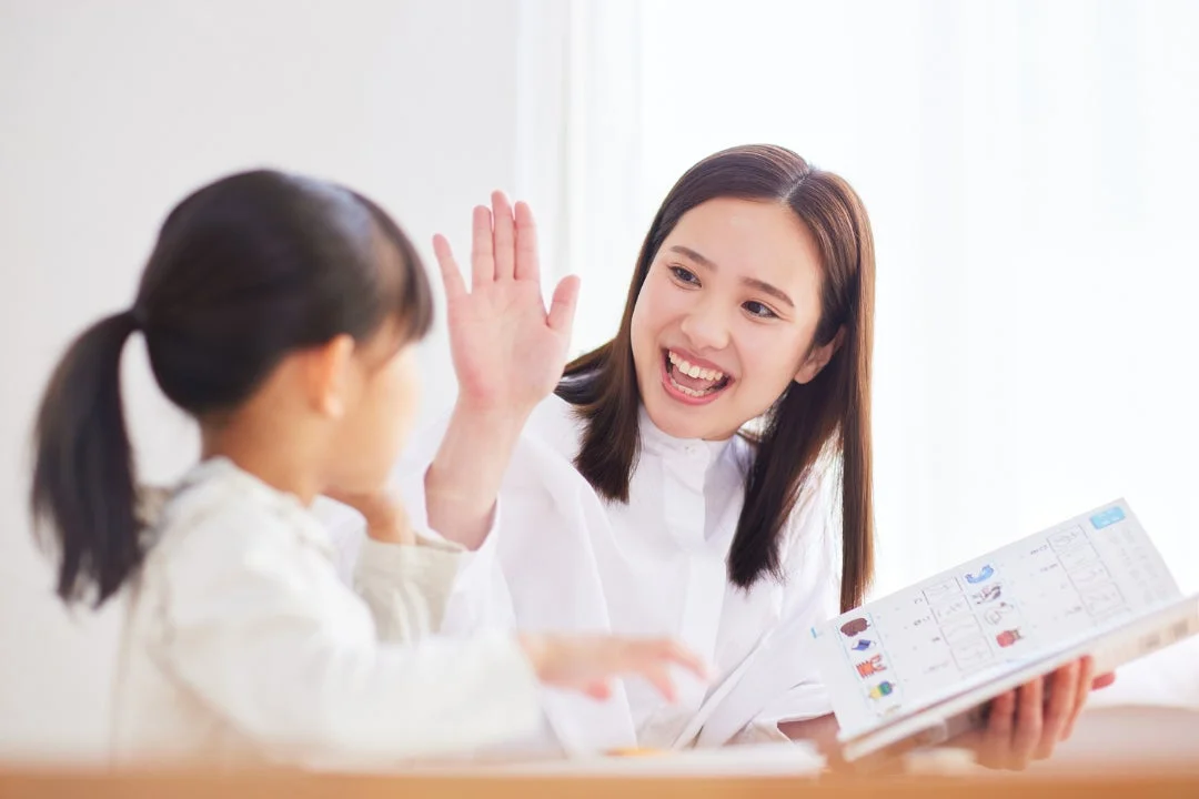 女性が子供とコミュニケーションをとっている画像