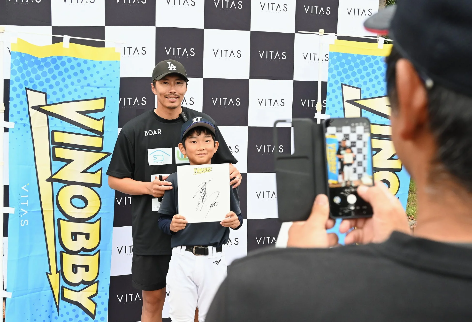 プロ野球選手と少年がサイン&撮影会をしている様子