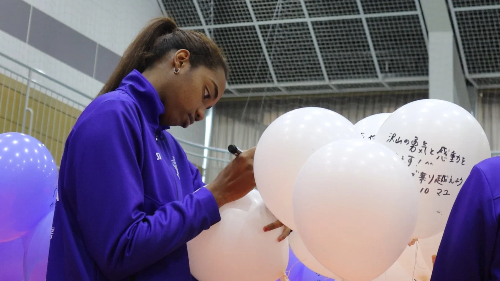 選手が風船にサインする様子