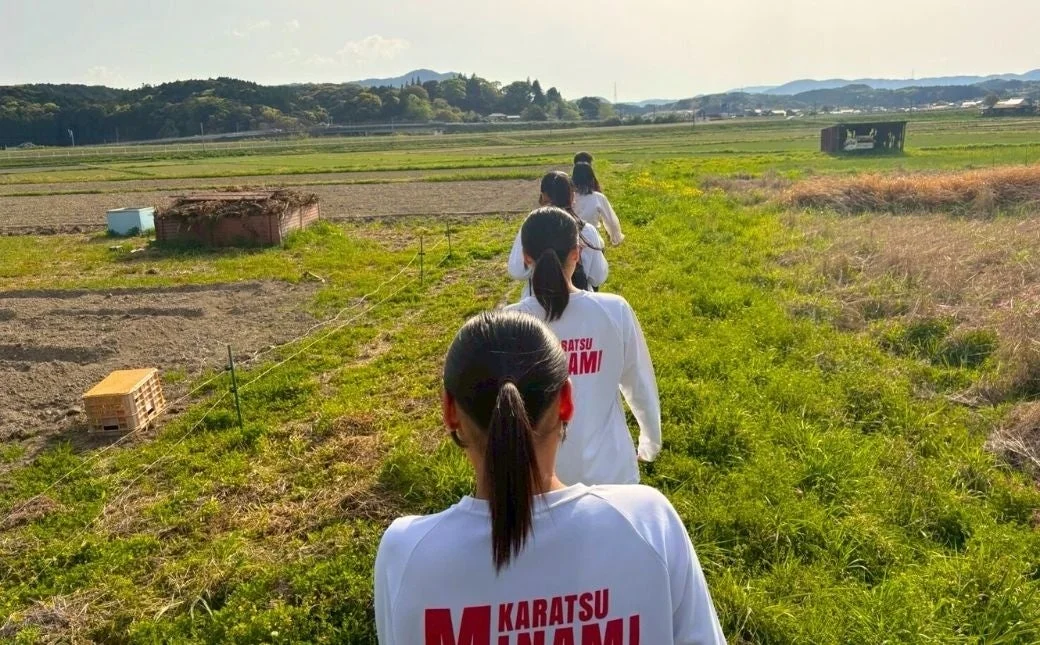 「KARATSU MINAMI」と書かれた服を着て歩く人々