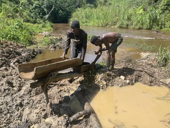 川で採掘作業をする男性たち