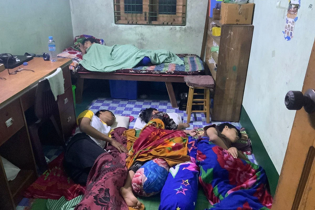 簡素な部屋で床に寝る子どもたち