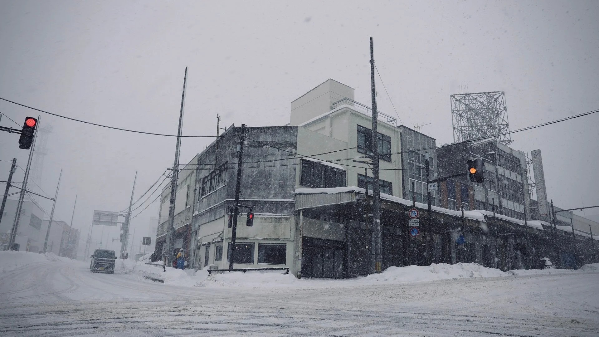 雪が降り積もる日本の街の交差点の風景