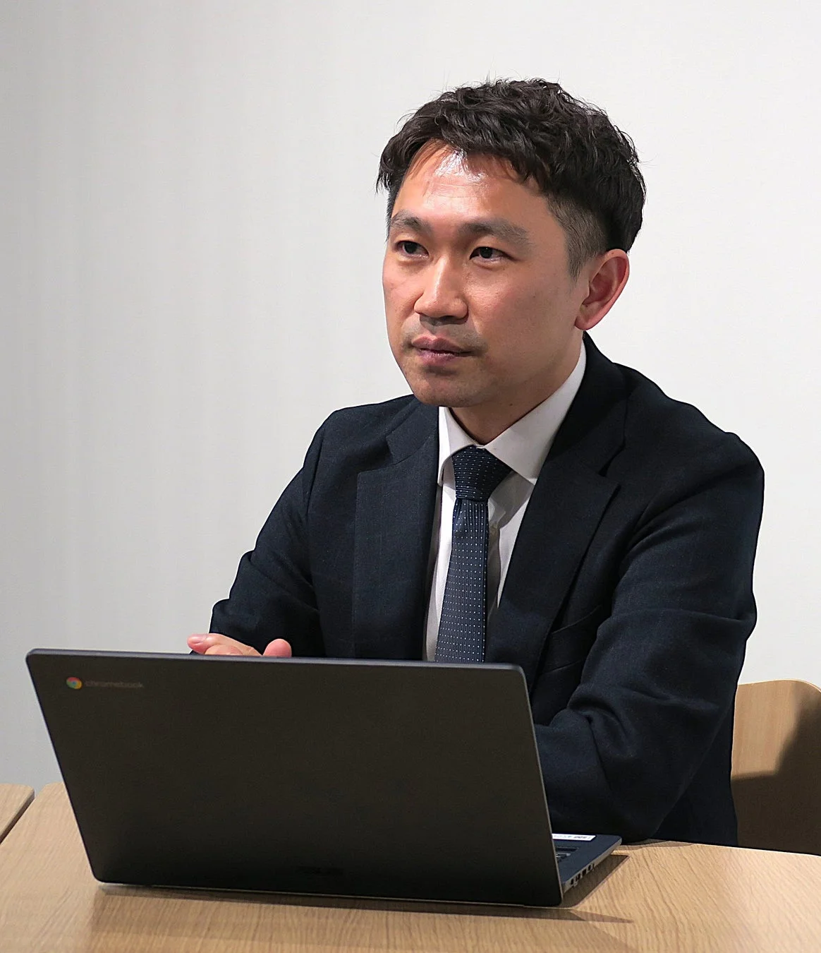 ノートパソコンを前に真剣な表情のビジネスマン