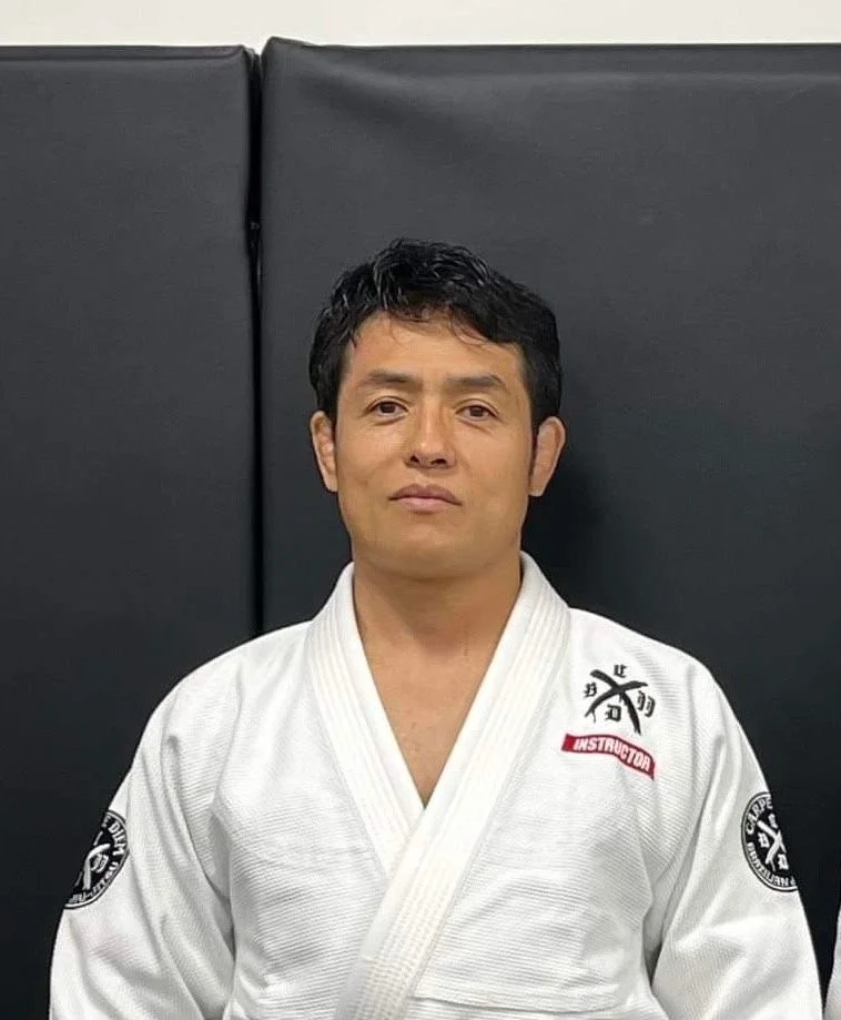 白い道着を着た男性がカメラを見つめているポートレート写真