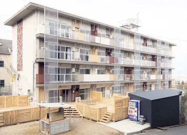 アパートメントビルディングの外観とウッドデッキ