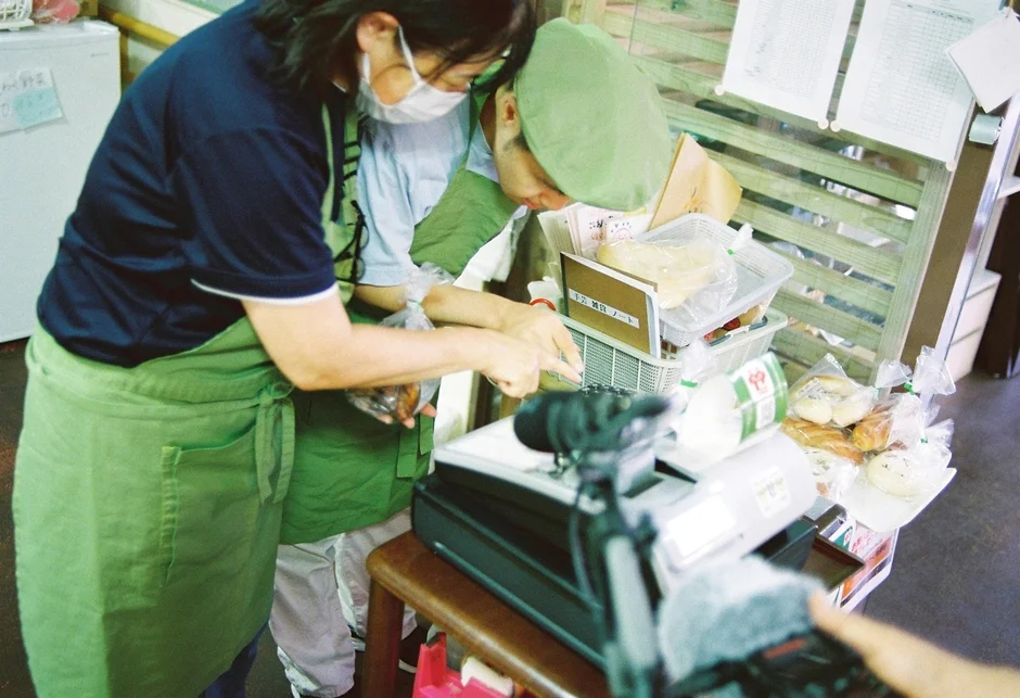 パンなどを販売する店内で作業している2人